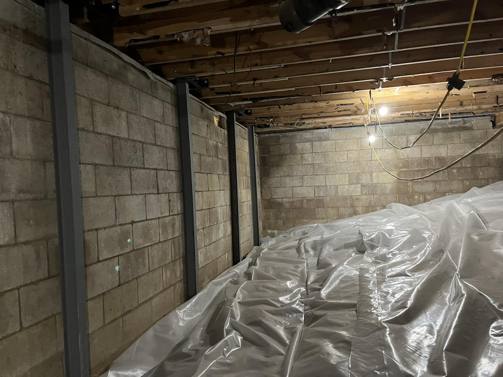 A basement with exposed cinder block walls and ceiling beams